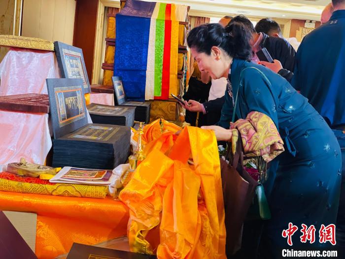 圖為現(xiàn)場(chǎng)藏族民眾向黃金書寫的大藏經(jīng)《甘珠爾》敬獻(xiàn)哈達(dá)?！O睿 攝