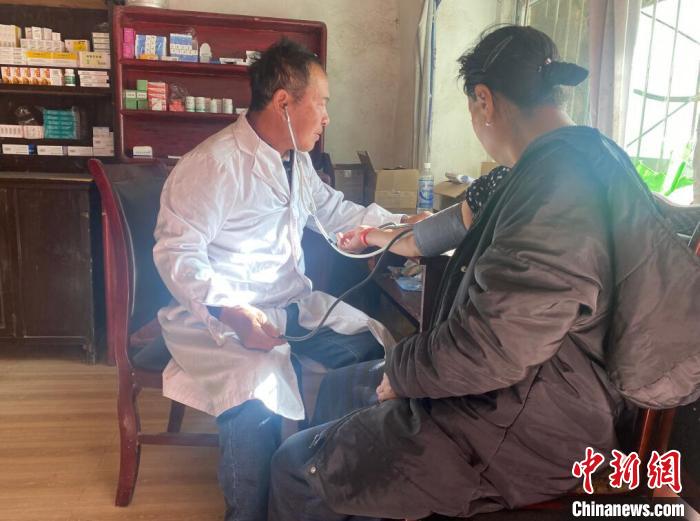 索木滾(左)為村民看病。　壤塘縣委宣傳部供圖