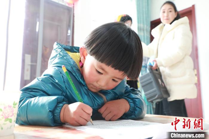 孩子們?cè)诩议T口上學(xué)，是楊周馬草搬入蘭州新家最為開心的事情。小女兒楊洋正在學(xué)習(xí)寫數(shù)字。　魏建軍 攝