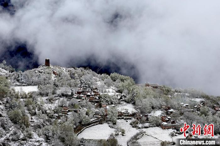 雪后的藏寨和碉樓構(gòu)成美麗的雪景?！〗党鯘衫?攝
