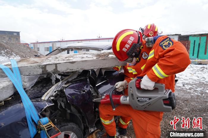 圖為地震實(shí)戰(zhàn)拉動(dòng)現(xiàn)場(chǎng)，參演人員進(jìn)行車輛破拆。　玉樹消防供圖