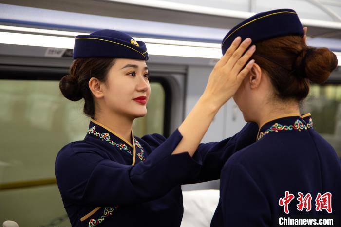 圖為青藏鐵路西格段“復(fù)興號(hào)”動(dòng)車組乘務(wù)員互相整理新制服?！±罾?攝