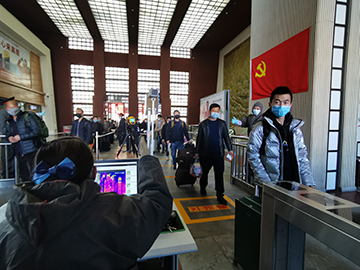 拉薩火車站工作人員對出站旅客進行紅外線測溫。趙越拍攝.jpg