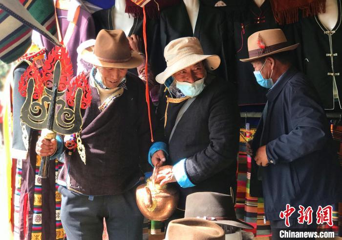 圖為三位藏族老人在集市上聊天交談。　冉文娟 攝