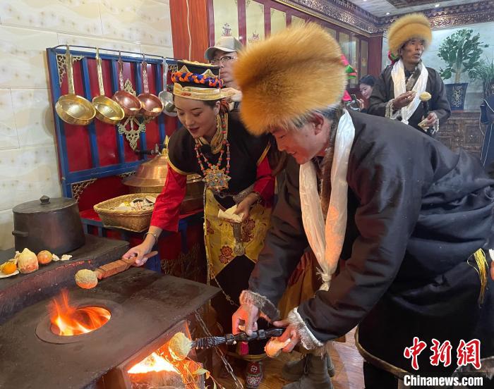 圖為人們?cè)诨鹕峡竟?jié)日美食“結(jié)達(dá)”?！∪轿木?攝