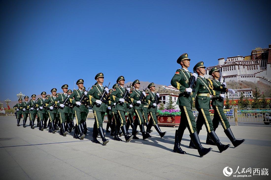 國旗護(hù)衛(wèi)隊(duì)隊(duì)員緊握鋼槍，踏著威武雄壯的步伐，走向國旗臺(tái)。人民網(wǎng) 次仁羅布攝