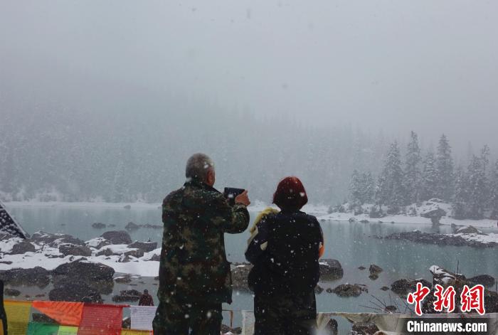 游客欣賞雪中然烏湖。　冉文娟 攝