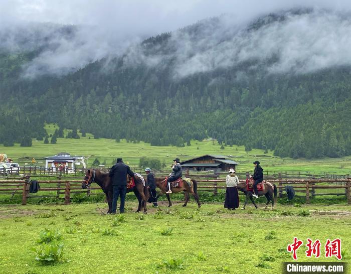 6月10日，游客在魯朗小鎮(zhèn)高山牧場(chǎng)景區(qū)體驗(yàn)騎馬。　冉文娟 攝