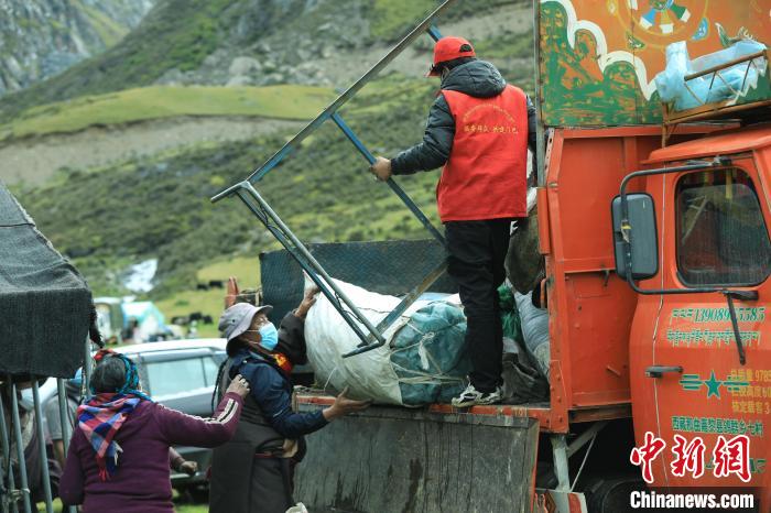 圖為工作人員幫助牧民們卸家具?！÷蹇?攝