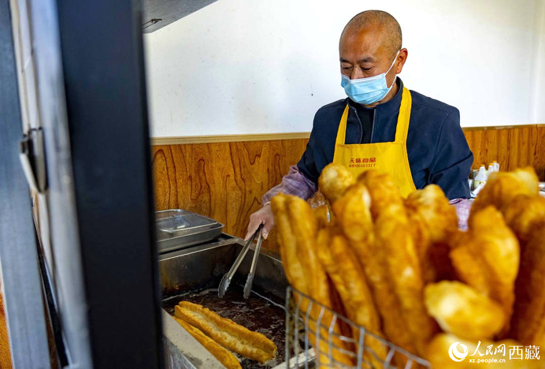 早餐店老板正在炸油條。人民網(wǎng) 次仁羅布攝