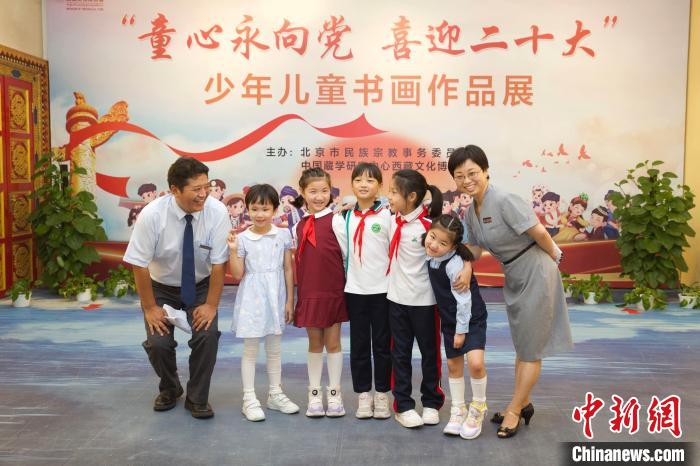 圖為與會嘉賓與入選畫作的“小作者”們在展覽上合影?！≈袊貙W(xué)研究中心供圖