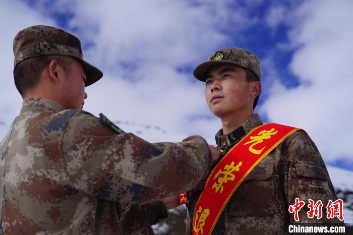 排長(zhǎng)王朝偉(圖左)給退伍老兵佩戴大紅花?！∥鞑厣侥宪姺謪^(qū)某團(tuán)供圖