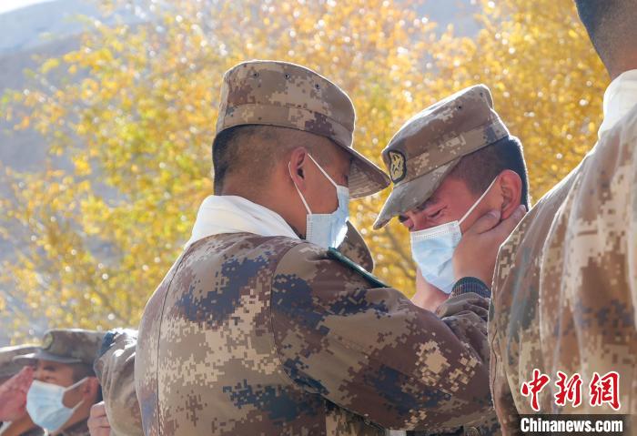 圖為什布奇邊防連退伍老兵與戰(zhàn)友相擁而泣，依依惜別?！⌒觳?攝