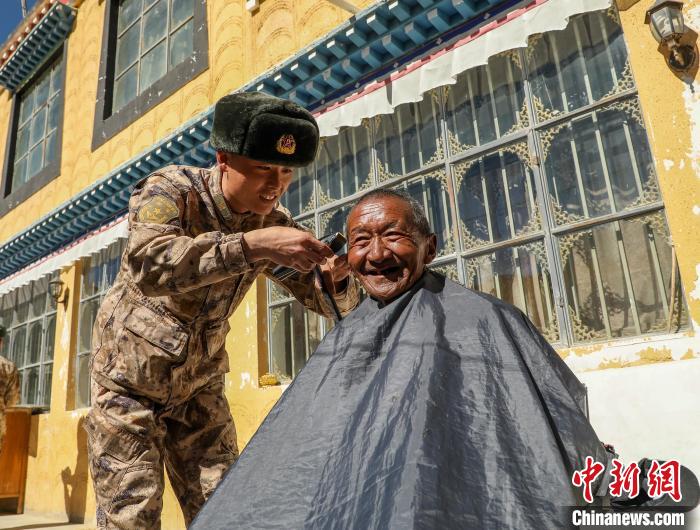 圖為阿里軍分區(qū)某邊防團官兵為駐地群眾理發(fā)迎藏歷新年?！〉┰鰝愔?攝
