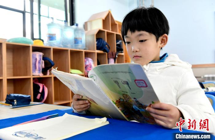 3月14日，西藏拉薩市第一小學(xué)一年級(jí)六班學(xué)生丁增樂吉在閱讀藏語課本?！±盍?攝
