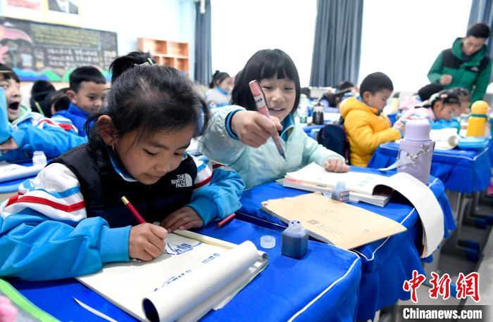 3月14日，西藏拉薩市第一小學(xué)一年級(jí)六班學(xué)生白瑪朗珍(圖左)在藏語文課上書寫藏文?！±盍?攝