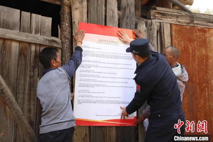 圖為亞?wèn)|邊檢站民警與駐地邊民群眾共同張貼國(guó)家安全知識(shí)教育海報(bào)?！?wèn)|邊檢站 供圖