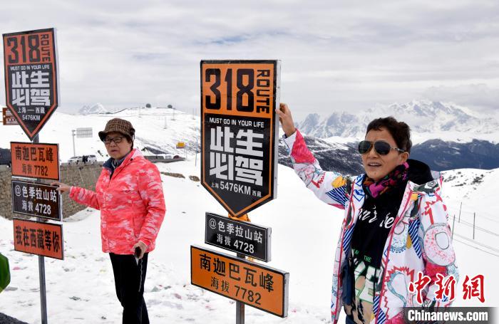 圖為5月14日，西藏林芝色季拉山觀景臺，游客與南迦巴瓦峰合影。　李林 攝