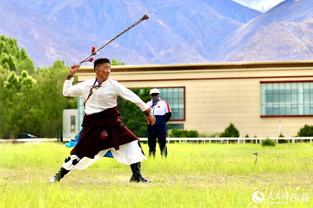 參賽選手在拉薩首屆農(nóng)牧民運(yùn)動(dòng)會(huì)上進(jìn)行“古朵”比賽（“古朵”指的是用牦牛毛或者山羊毛編織成的拋石繩，可以將石頭投擲到較遠(yuǎn)的地方，是牧民們用來放牧的工具）。