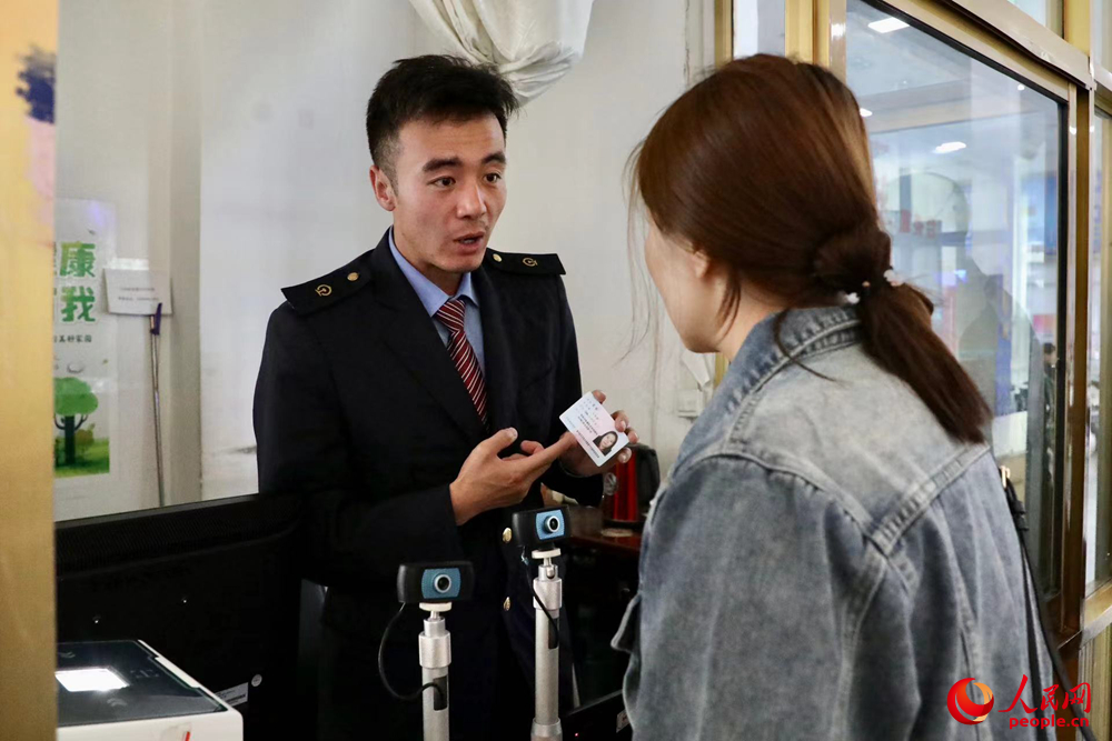 車站工作人員向旅客解答疑問。人民網(wǎng)記者 次仁羅布攝